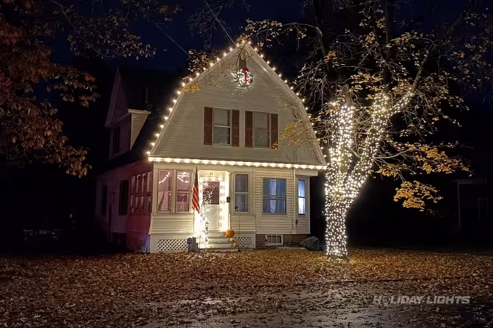 Roofline Christmas decoration with tree trunk wrapping in warm white LED lights